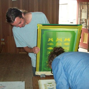 Taking a break from his papermaking workshop, Nathaniel Marchand helps the Silkscreen Club.